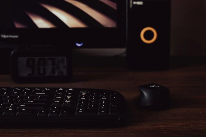 a computer keyboard and mouse on a desk